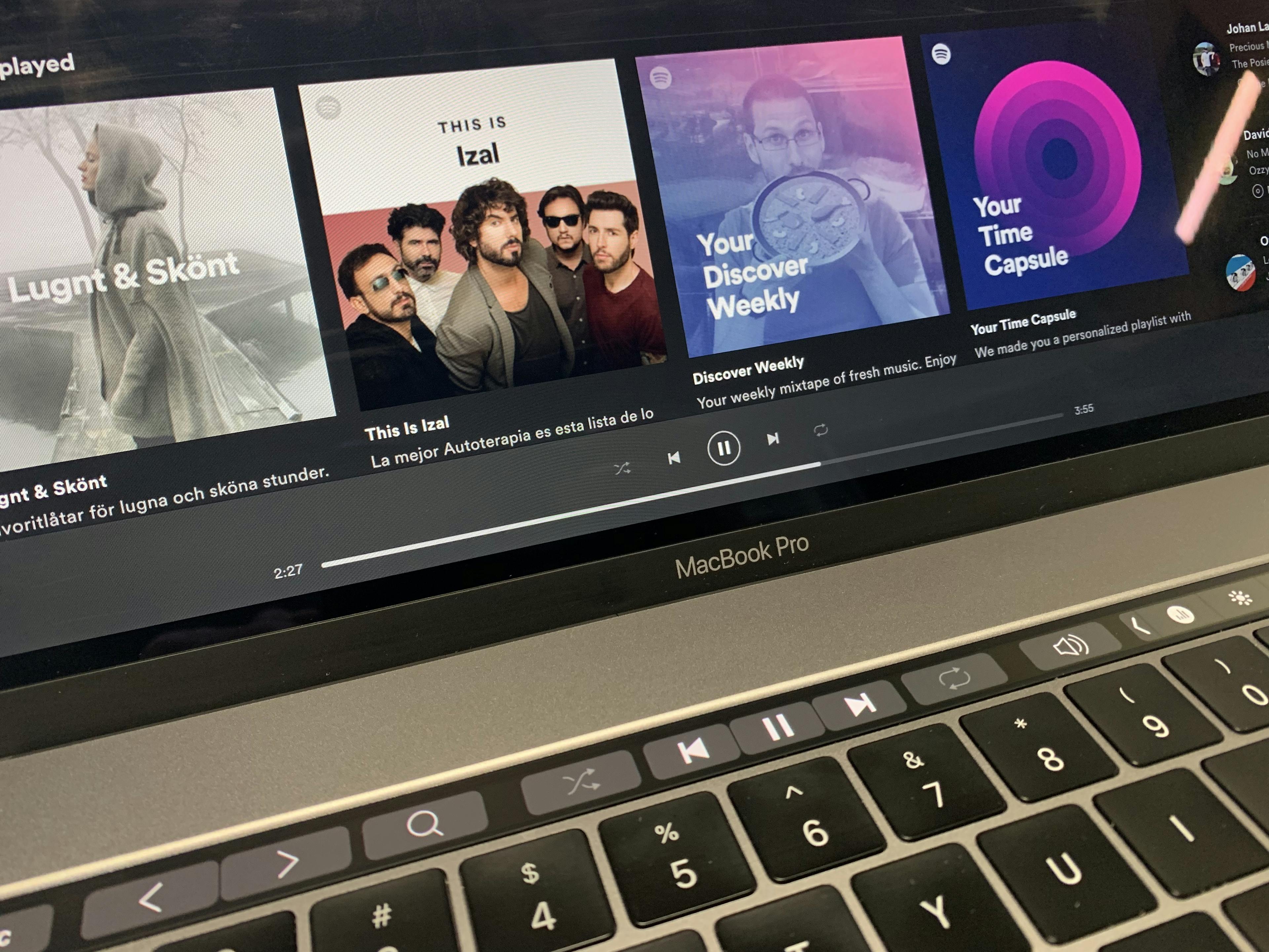 Picture of a Macbook Pro running the Spotify app, with custom controls in the Touch Bar